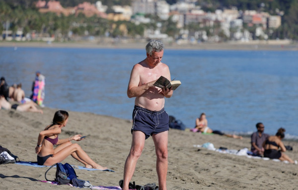Um turista lê um livro durante um inverno excepcionalmente quente na praia de Malagueta, em Málaga, no sul da Espanha.[로이터]